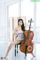 A woman sitting on a chair holding a cello.